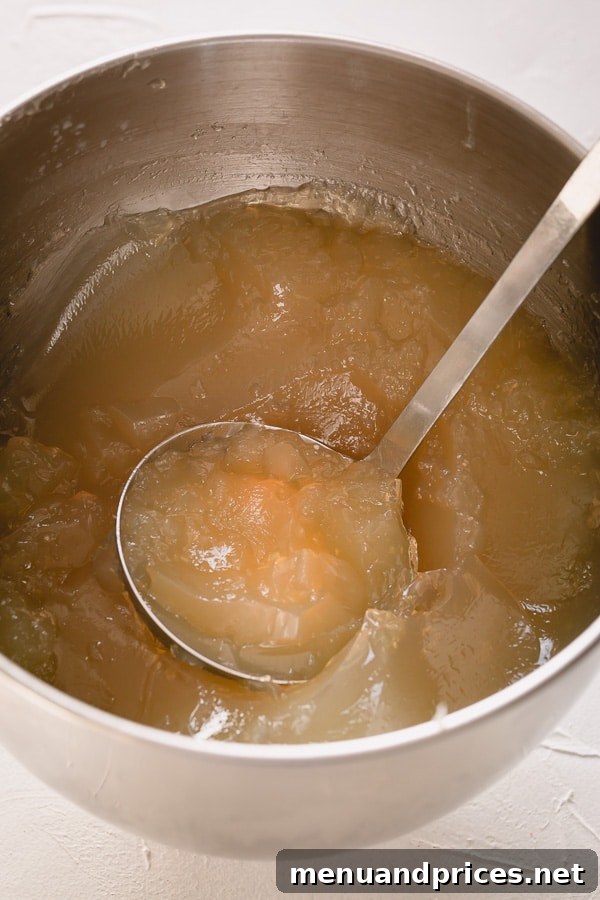 Homemade Beef Bone Broth: Simmering Wellness in Every Sip 5 Rich, gelatinous beef bone broth poured into a glass, showcasing its vibrant color and texture.