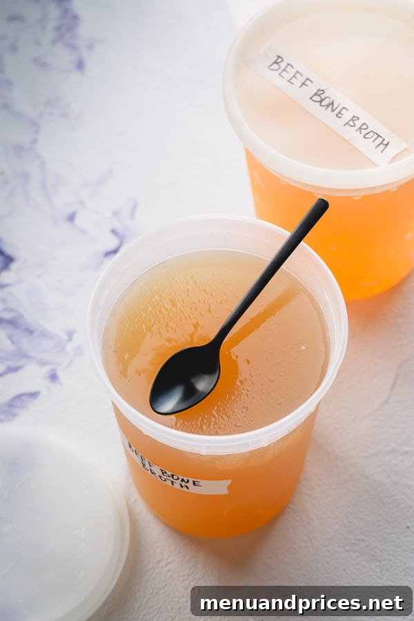 Homemade Beef Bone Broth: Simmering Wellness in Every Sip 6 Portioned beef bone broth stored in various freezer-safe containers for convenient future use.