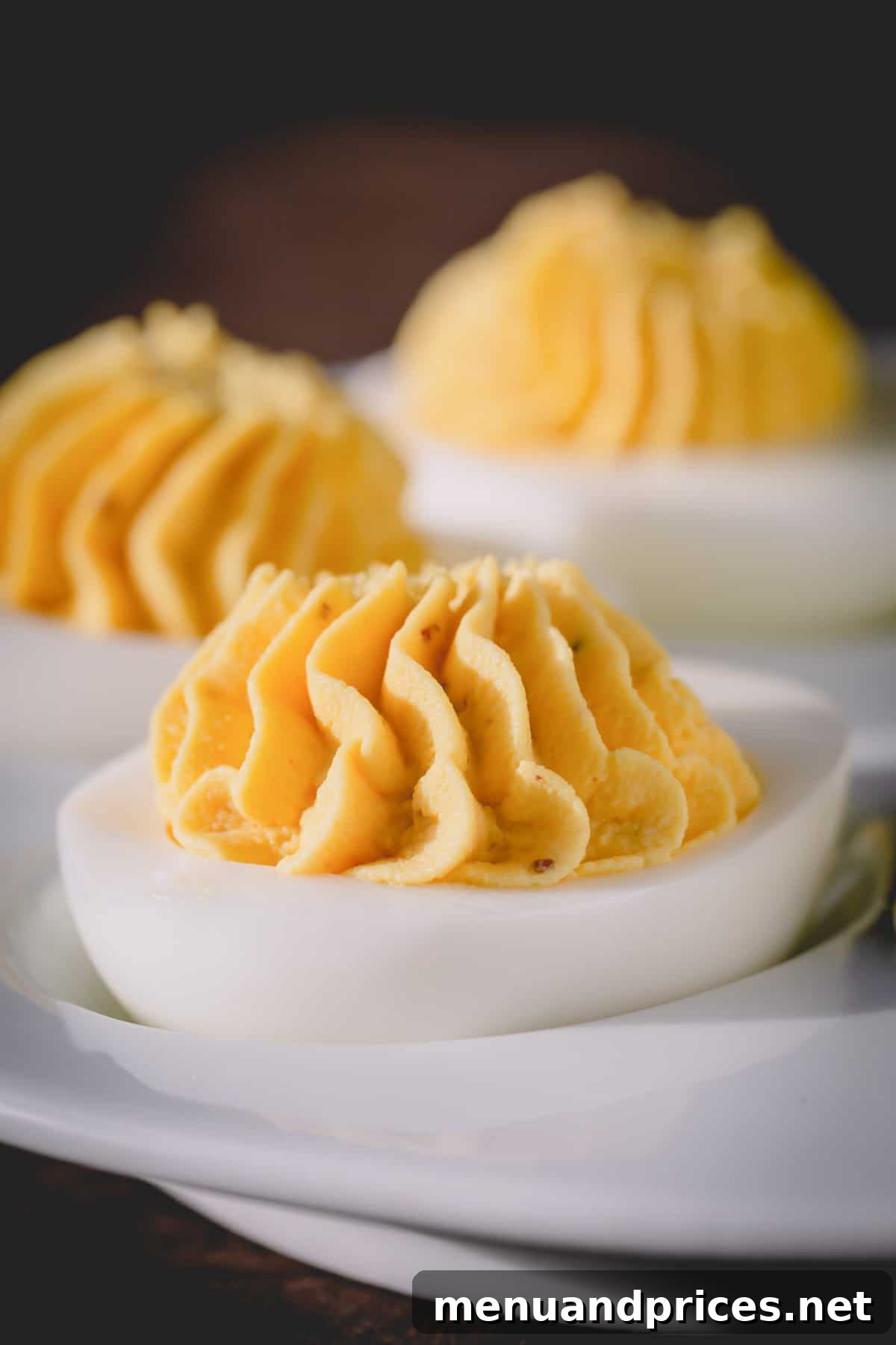 Simple Steps to Irresistible Deviled Eggs 6 A close-up shot of a perfectly piped deviled egg, garnished with fresh dill, showcasing its creamy texture and appealing presentation.