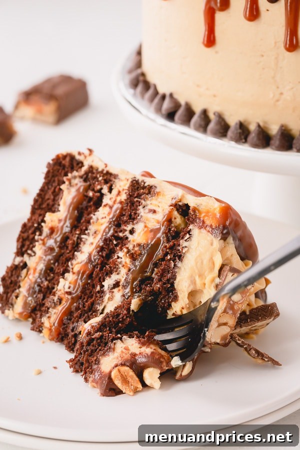 This irresistible Snickers Cake is made of layers of softest chocolate cake, caramel buttercream, peanut butter buttercream, salted caramel and generous amount of crushed peanuts!!! Step by step photos are included for your success! #snickerscake #layercake