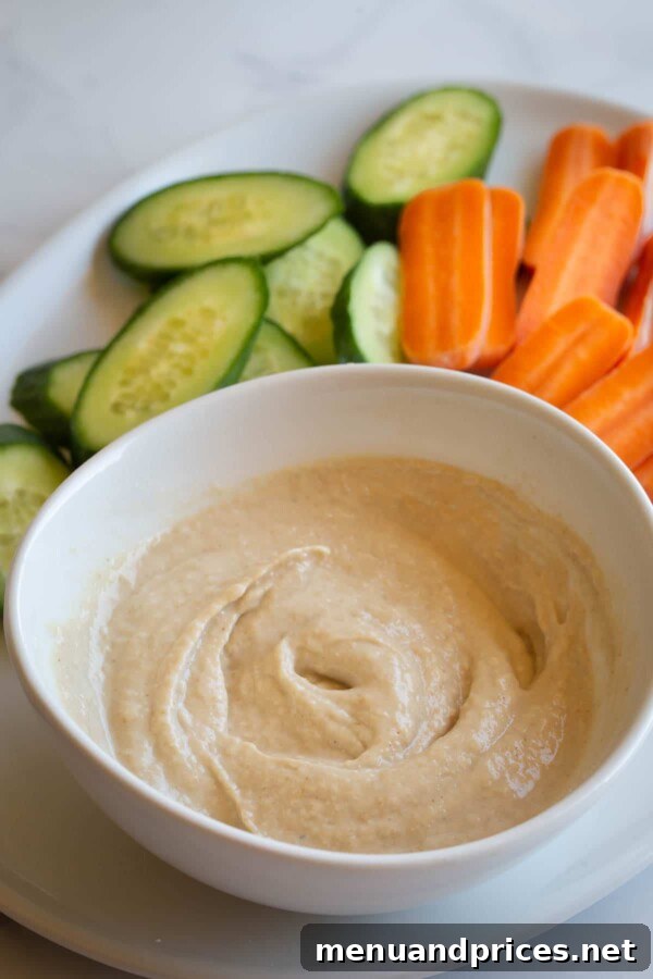 A visually appealing spread of various dipping sauces in small white bowls, each distinctly different in color and texture, presented with a variety of dippable snacks.