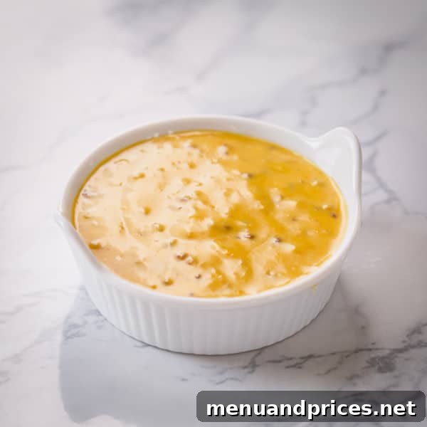 A small bowl of homemade honey mustard sauce, a golden and creamy condiment perfect for dipping.
