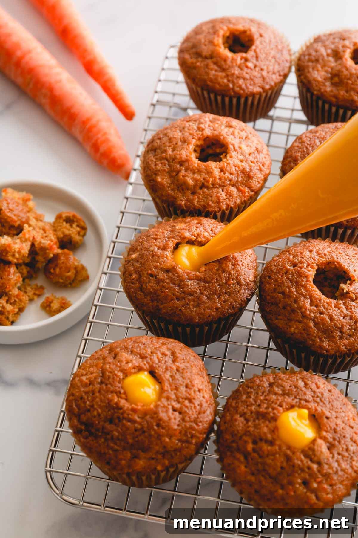 Spiced Carrot Cupcakes 12 A trio of cored carrot cupcakes, now filled with a vibrant yellow pineapple curd, creating a delightful surprise center.