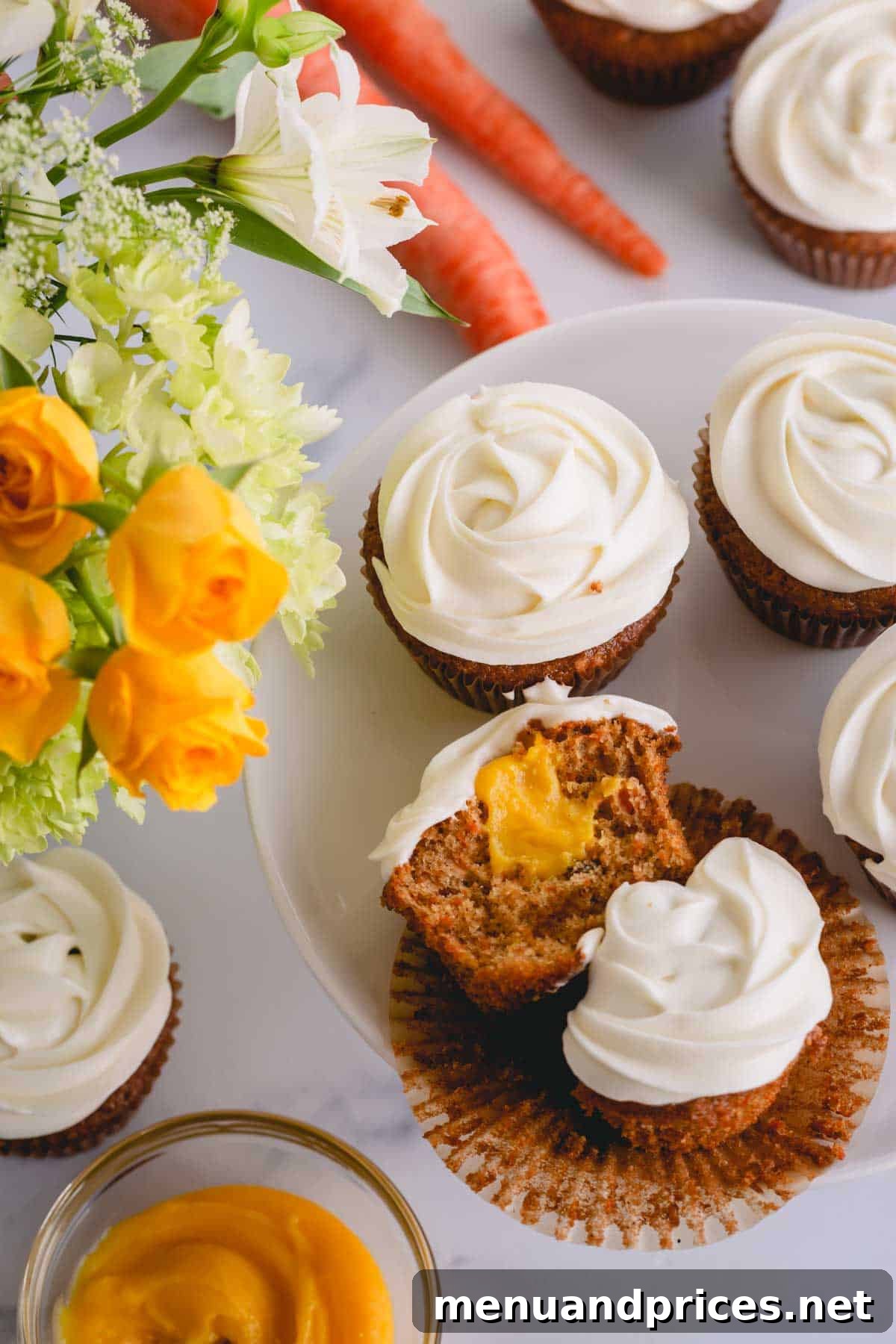 Spiced Carrot Cupcakes 13 A beautifully frosted carrot cake cupcake, expertly cut in half to reveal the rich, moist cake and the delightful, vibrant pineapple curd filling.