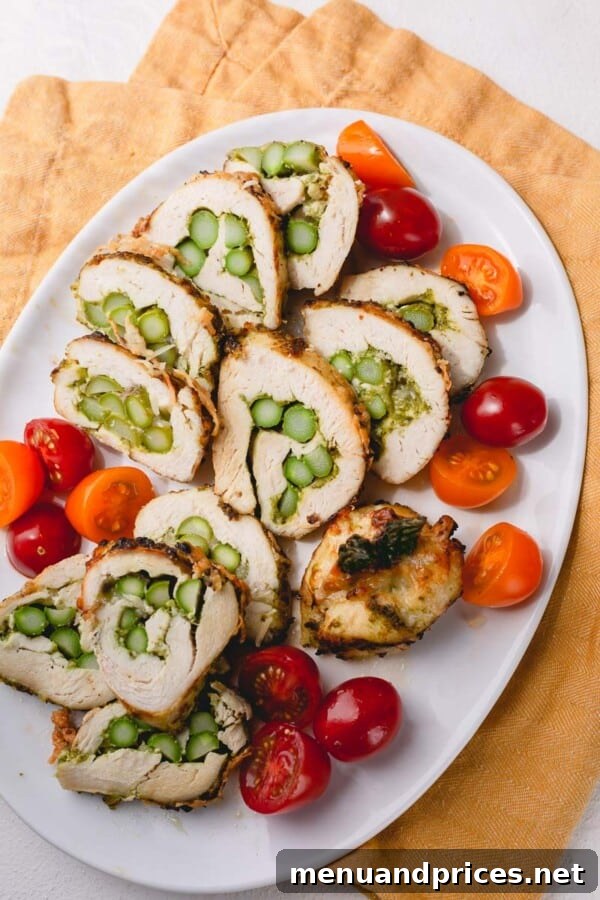 Golden-brown pesto chicken and asparagus roll-ups on a baking sheet, ready to be served.