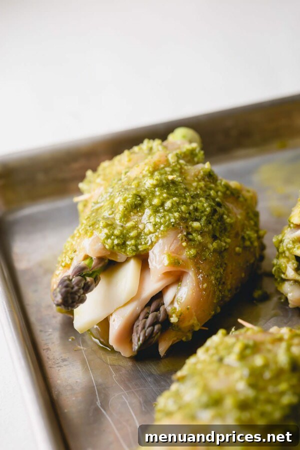 Flattened chicken breasts laid out, ready for filling with pesto, asparagus, and cheese.