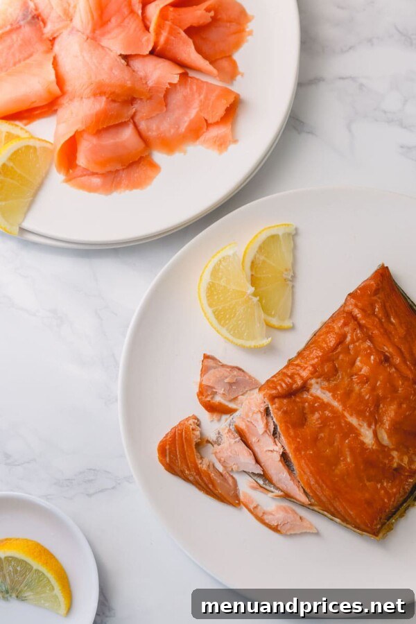 Smoked Salmon Silky Cold or Flaky Hot 3 A rustic presentation of various cuts and forms of smoked salmon, showcasing its rich color variations and inviting textures.
