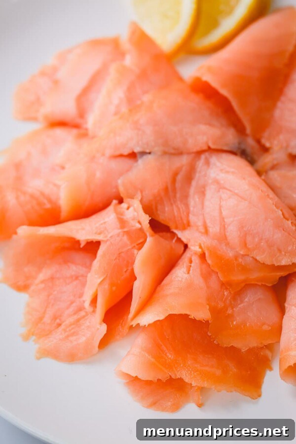 Smoked Salmon Silky Cold or Flaky Hot 5 Thin, translucent slices of pinkish-orange cold-smoked salmon, showcasing its delicate and silky texture.