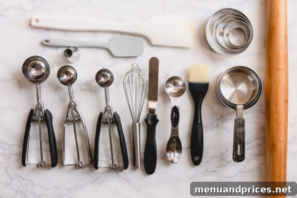 The Ultimate 22-Item Baking Starter Kit 2 A curated collection of essential baking tools neatly arranged on a kitchen counter, showcasing various pans, spatulas, and measuring devices.