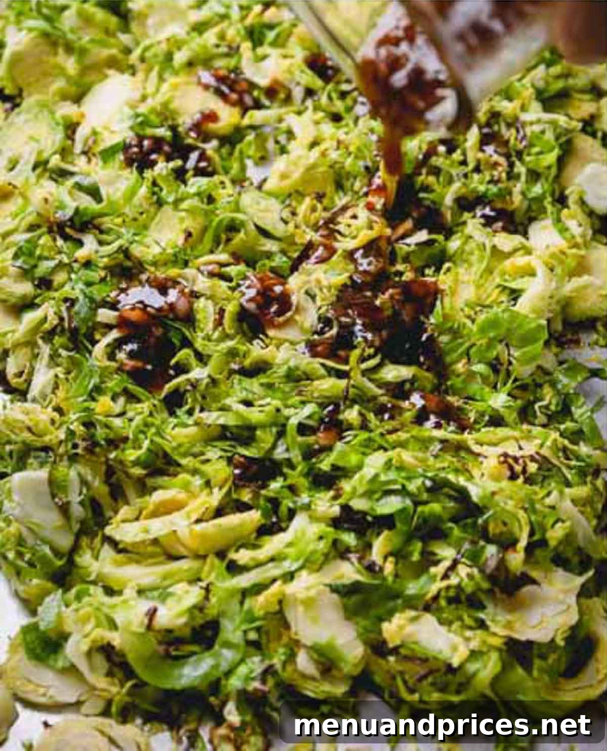 Brussels Sprout Ribbon Salad with Pomegranate 5 A continuous stream of rich pomegranate vinaigrette being artfully poured over a bowl filled with freshly roasted Brussels sprouts.