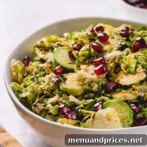 A bowl of roasted shaved Brussels sprouts topped with pomegranate arils.