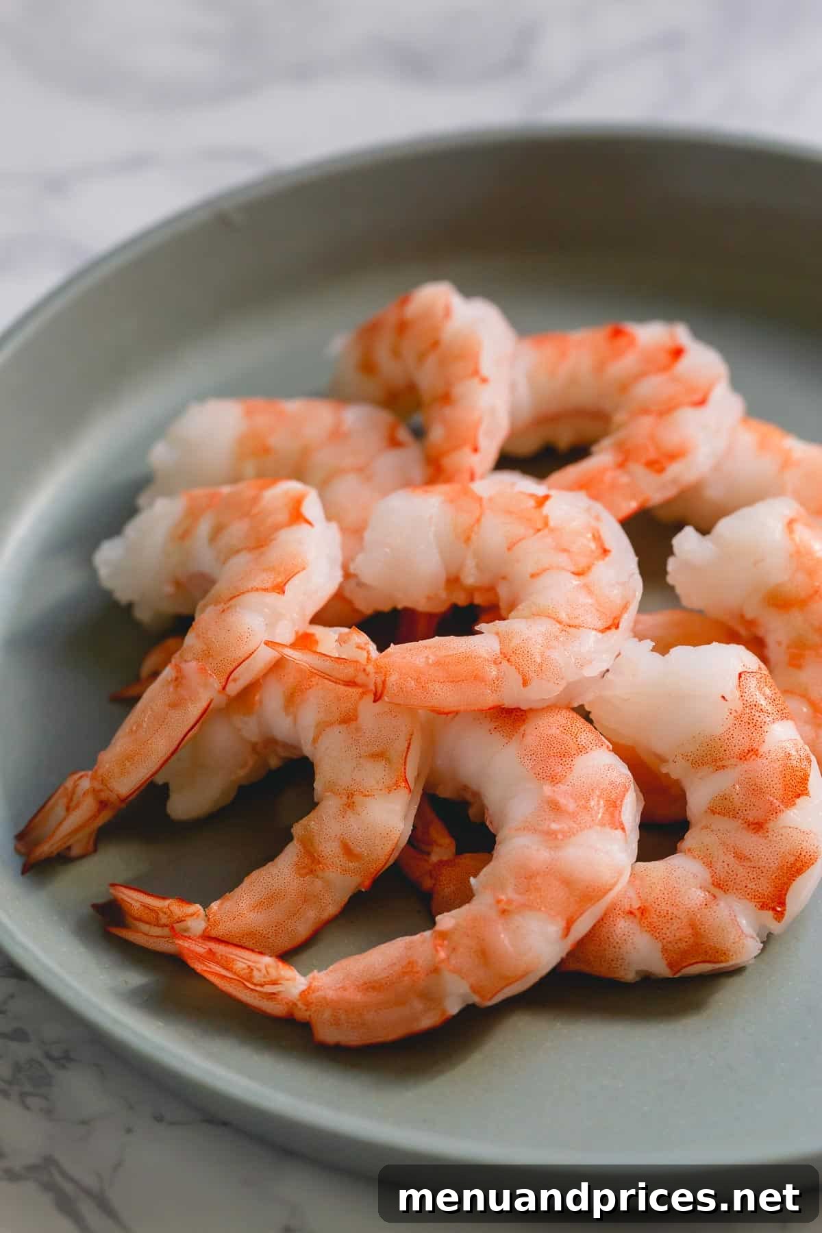 Perfectly Boiled Shrimp Every Time 7 A generous pile of cooked shrimp presented on a simple white plate, ready to be served.