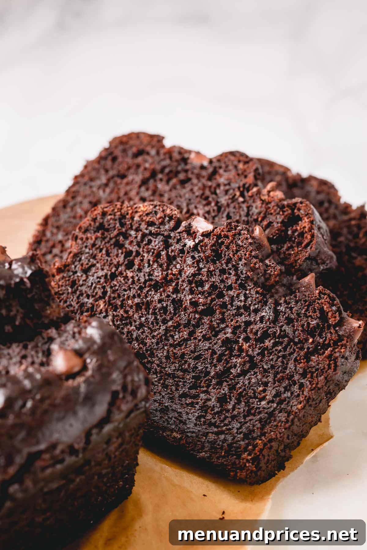 Fudgy Chocolate Banana Bread 2 Slices of incredibly moist and rich chocolate banana bread on a cutting board, ready to be enjoyed.