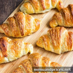 A close-up of a beautifully baked homemade croissant, golden brown and perfectly flaky.