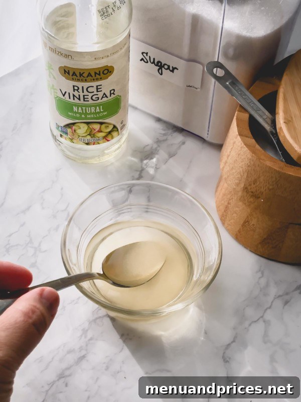 Unlock the Art of Sushi Rice 4 Sushi vinegar seasoning mixture in a small bowl with a whisk, showing the dissolved ingredients