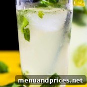 A close-up of a beautifully garnished Coconut Mojito in a tall glass, ready for drinking.