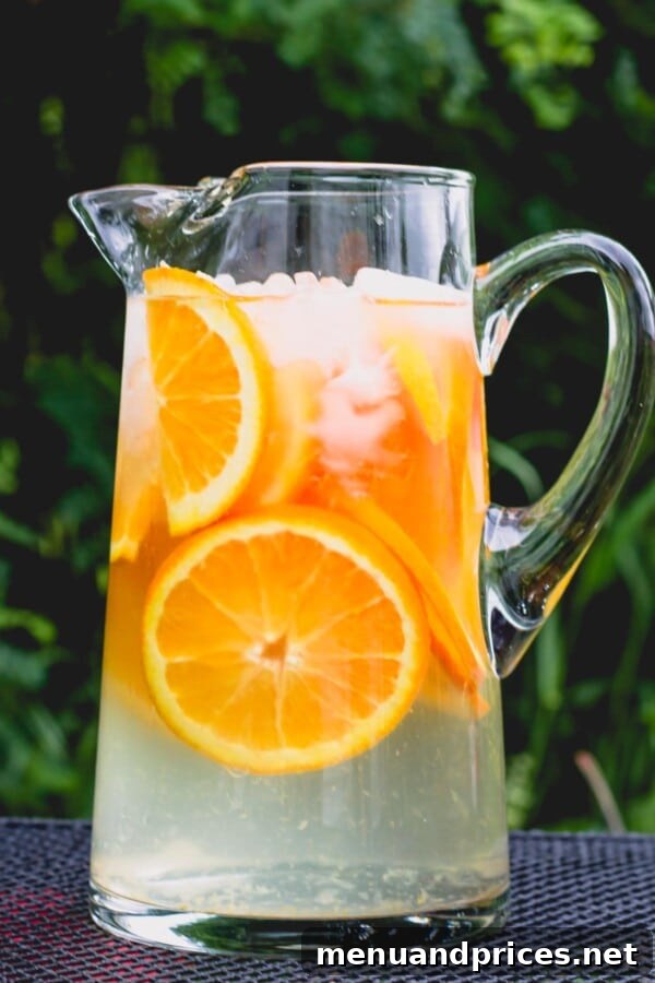 Three Zesty Infused Waters for Ultimate Refreshment 5 A glass of Simply Citrus Water with thin slices of orange and ice, offering a refreshing and simple flavor.