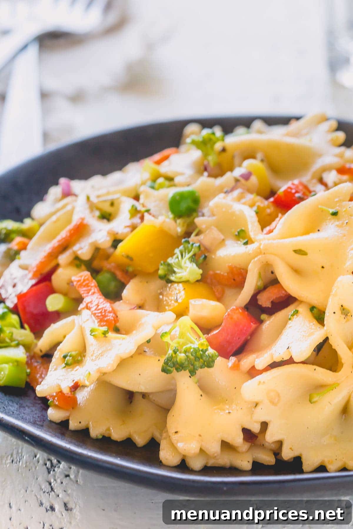 Vibrant Veggie Pasta Salad 3 Close-up of Farfalle Pasta Salad with colorful vegetables, showcasing the texture and dressing clinging to the pasta.