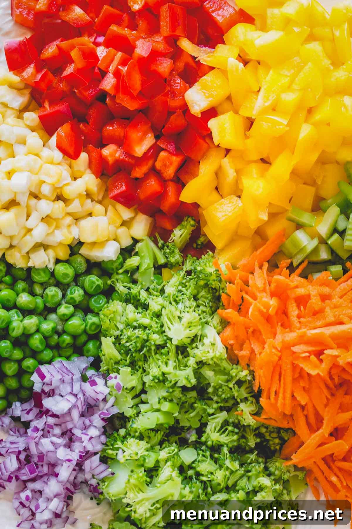 Vibrant Veggie Pasta Salad 4 Platter of freshly chopped rainbow vegetables arranged before mixing, including bell peppers, celery, carrots, and basil, ready for assembly.