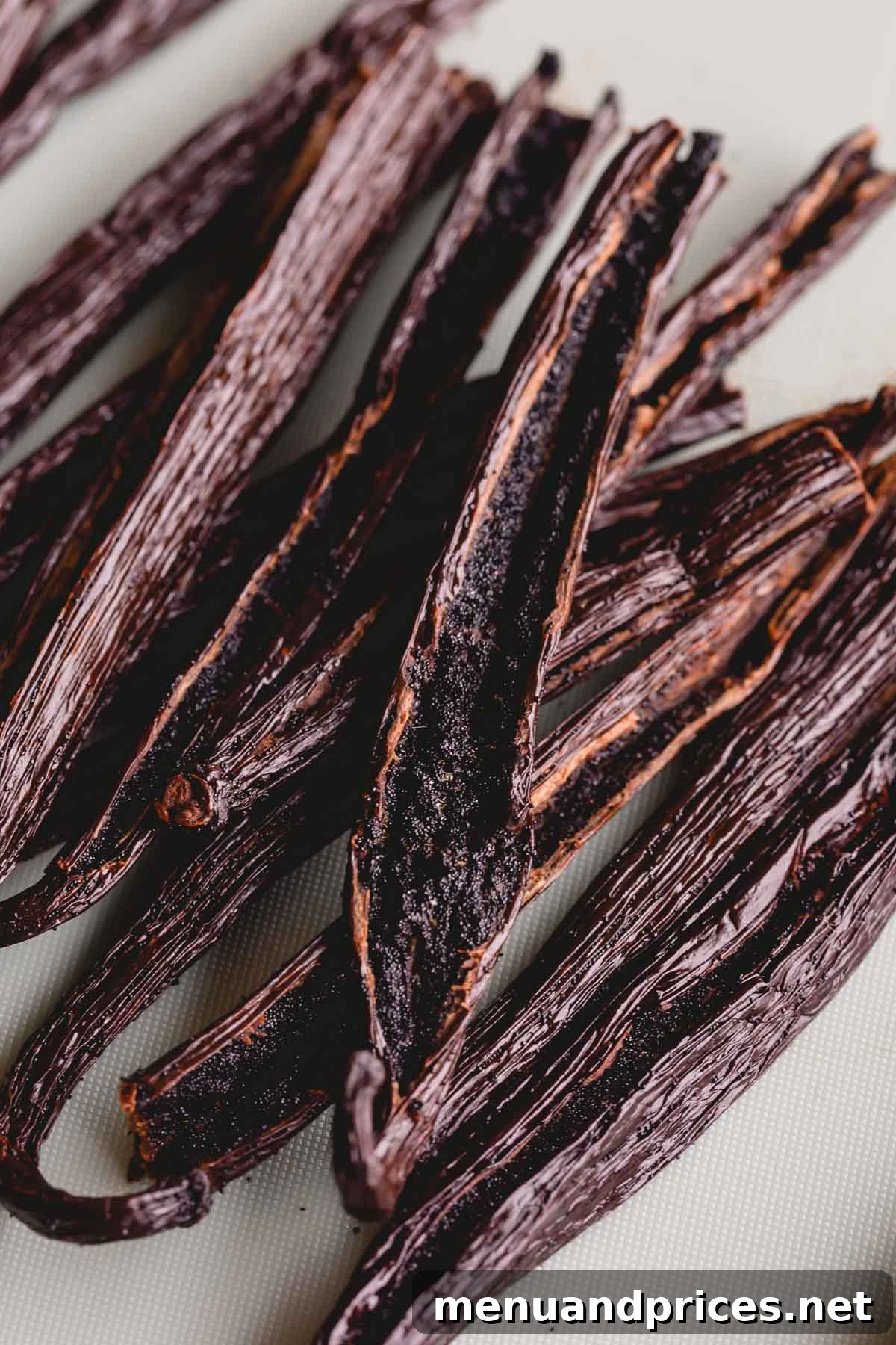 The Art of Homemade Vanilla Extract 4 Vanilla beans sliced lengthwise with exposed seeds, ready for extraction.