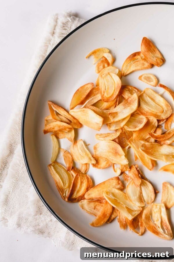 A beautifully presented dish, likely a stir-fry or noodle bowl, generously garnished with golden fried garlic slices.