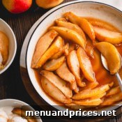 Caramelized pear slices with sauce in a white plate.