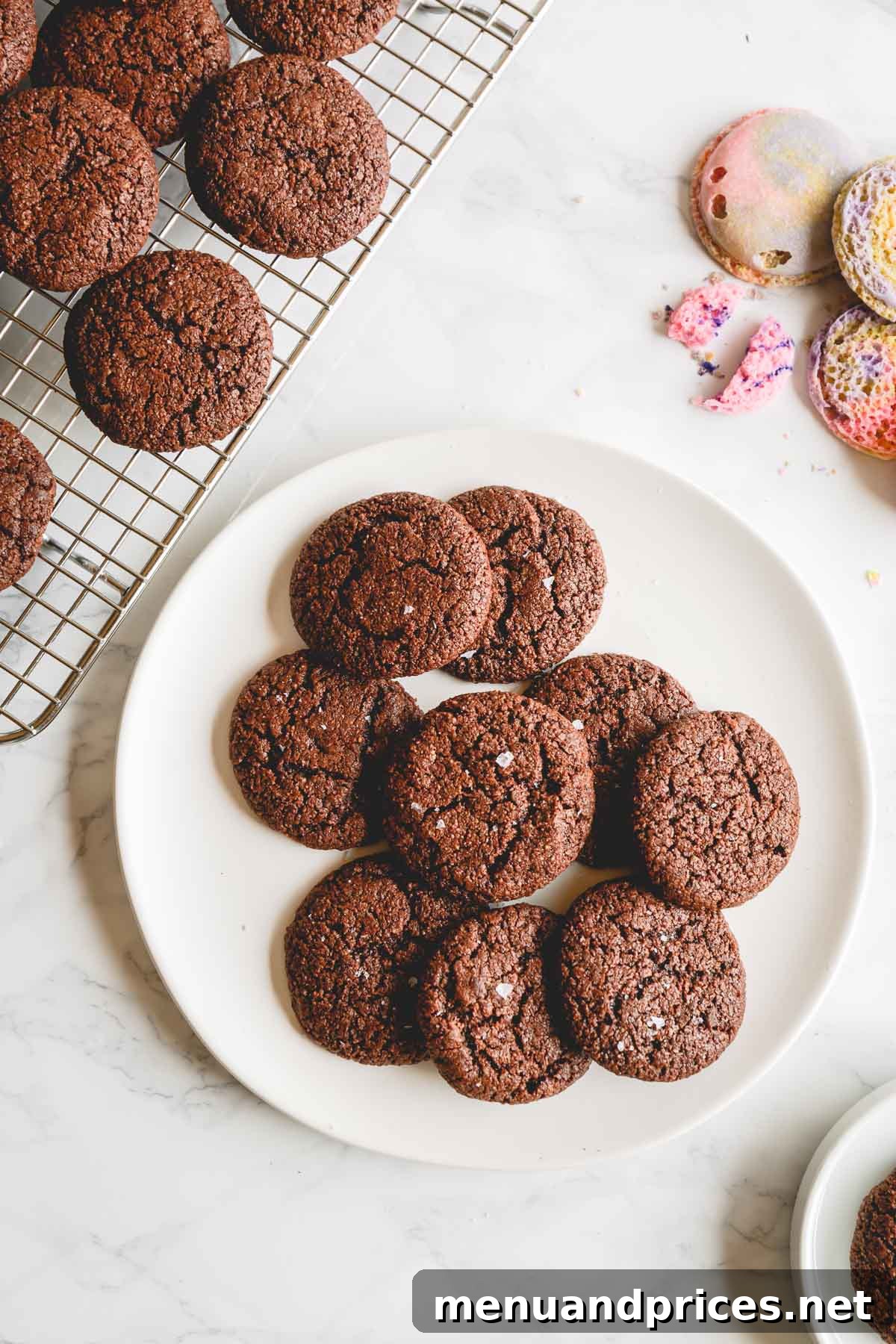 Overhead shot of perfectly baked macaron brownie cookies arranged on a pristine white plate, inviting indulgence.