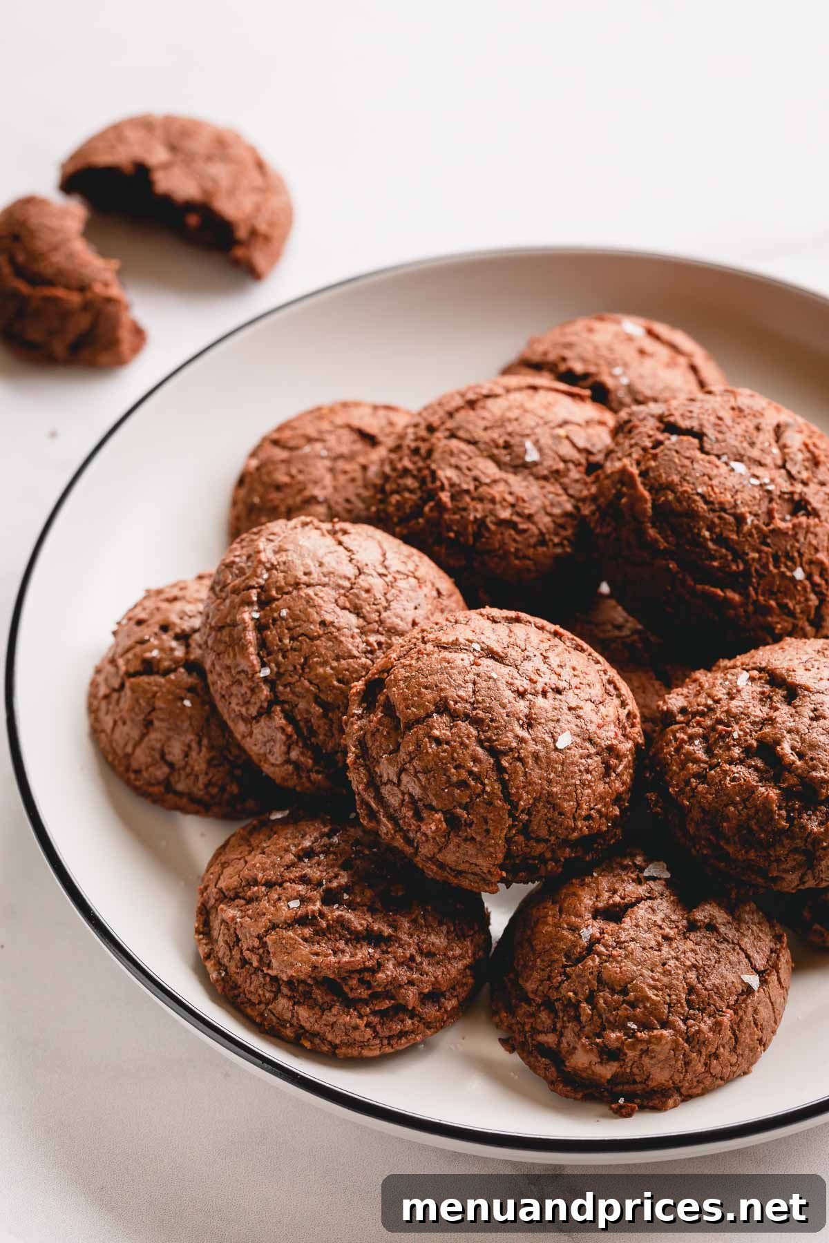 A plate of perfectly baked, rich chocolate macaron brownie cookies, showcasing their inviting texture and dark color.