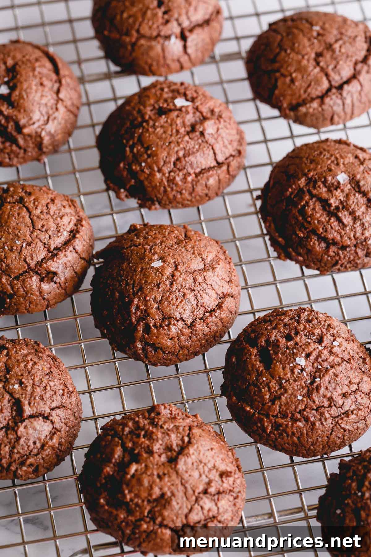 A batch of freshly baked, rich chocolate brownie cookies cooling on a wire rack, highlighting their tempting appearance and readiness to be enjoyed.