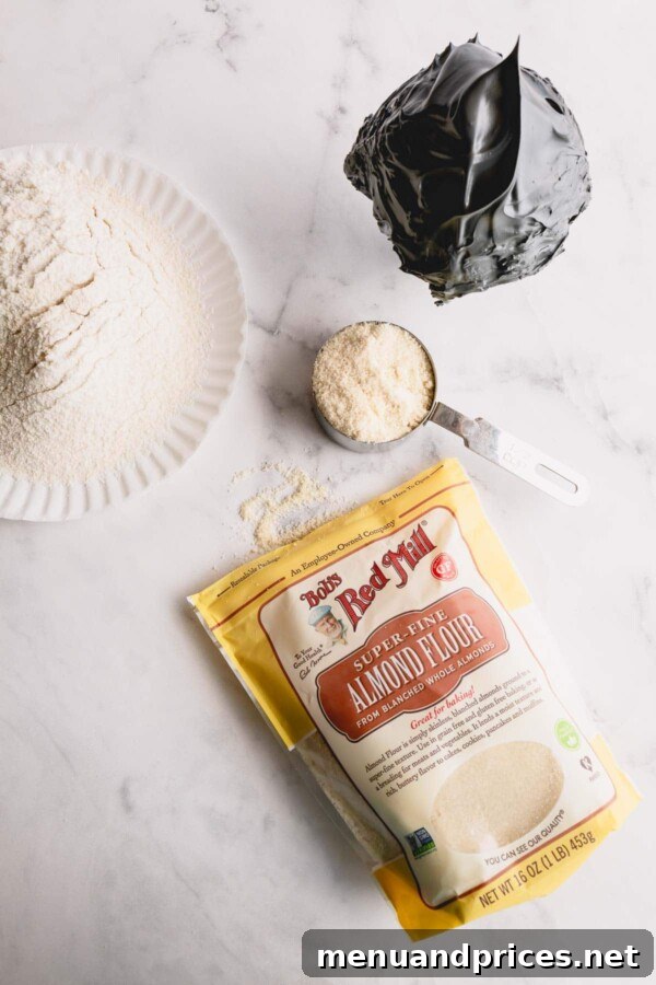 Close-up of almond flour and powdered sugar being sifted into a bowl through a fine-mesh sieve, demonstrating a crucial step for smooth macaron shells.