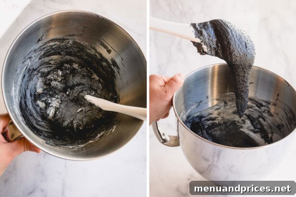 Macaron batter in a mixing bowl being folded with a silicone spatula to reach the perfect 'lava-like' consistency for piping.