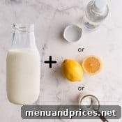 Bottle of milk with cream of tartar, white vinegar and lemon, representing buttermilk replacement ingredients.