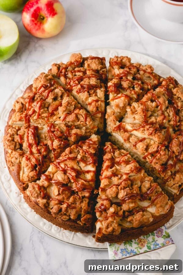 Spiced Apple Streusel Coffee Cake 3 A pristine slice of apple coffee cake, showing its layered texture and tender crumb, resting on a white serving plate.