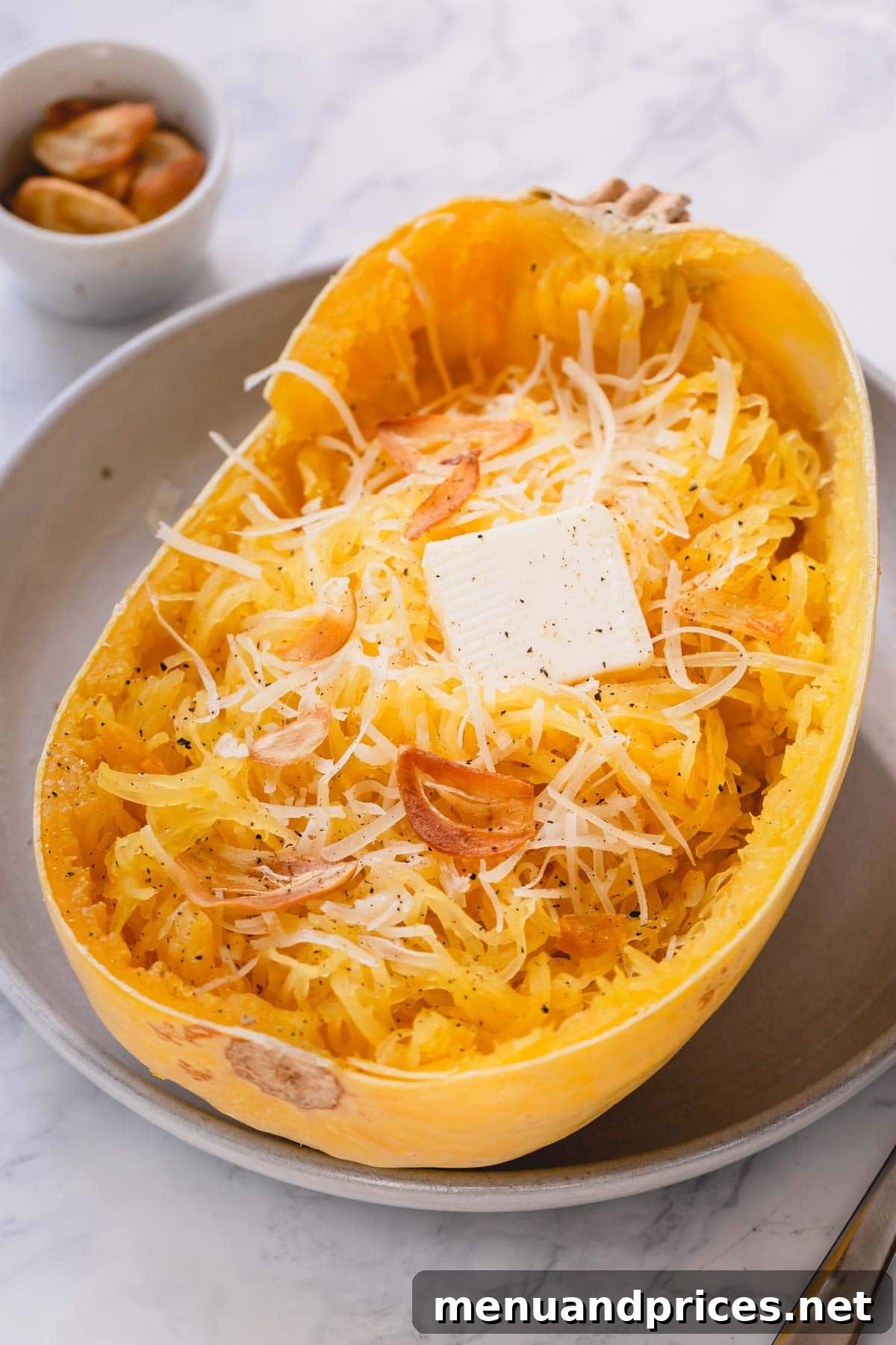 Master Spaghetti Squash Two Ways 7 Half of baked spaghetti squash with butter and parmesan cheese.
