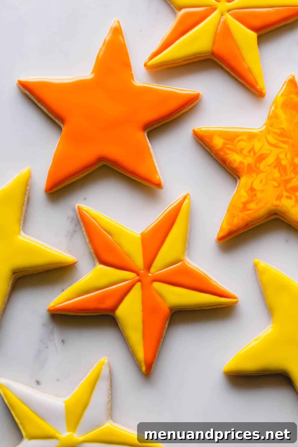 The Perfect No-Spread Sugar Cookies 11 Star shaped sugar cookies decorated with yellow and orange royal icing.