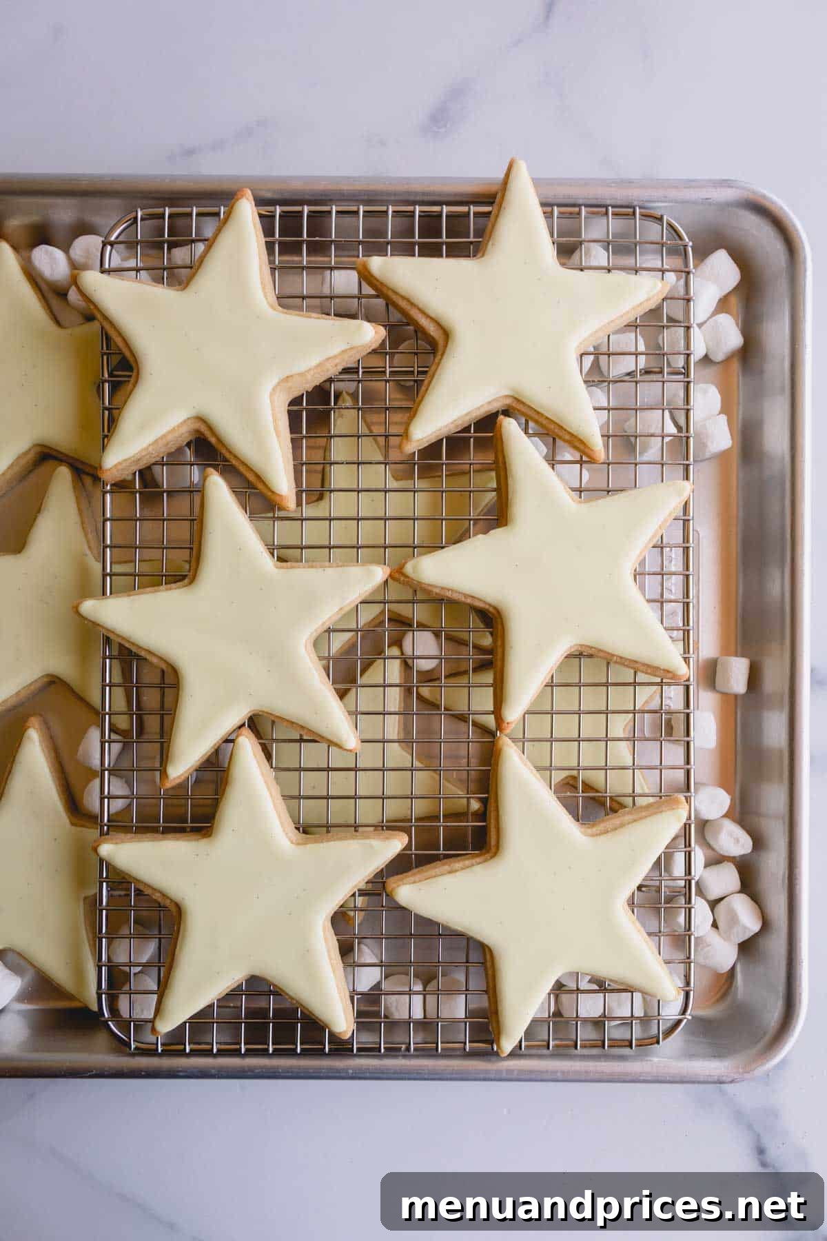 The Perfect No-Spread Sugar Cookies 12 Yellow iced star cookies on a wire rack.