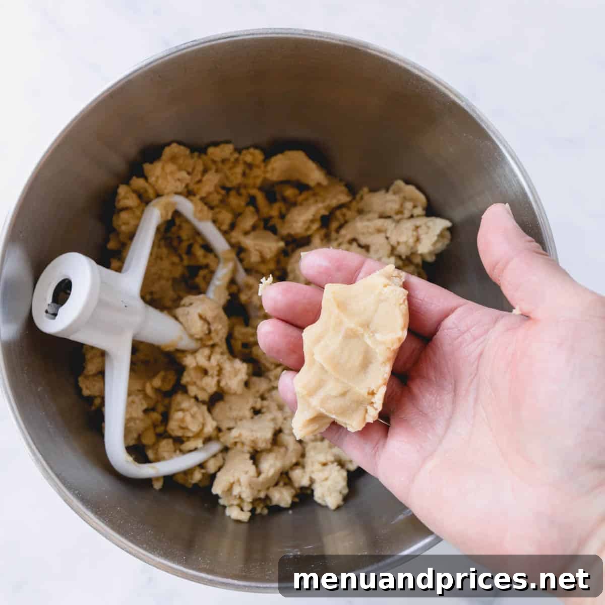 The Perfect No-Spread Sugar Cookies 6 Crumbly cookie dough in a mixing bowl and some squeezed in hand.