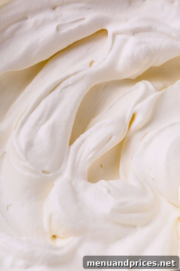 Decadent Tiramisu Dream Cake 4 Close-up image of fluffy, pristine white tiramisu cream filling, showing its airy texture.