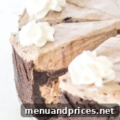 Oreo Dream Cake 6 A perfectly sliced piece of double-layered Oreo ice cream cake with a creamy filling and crumbly crust.