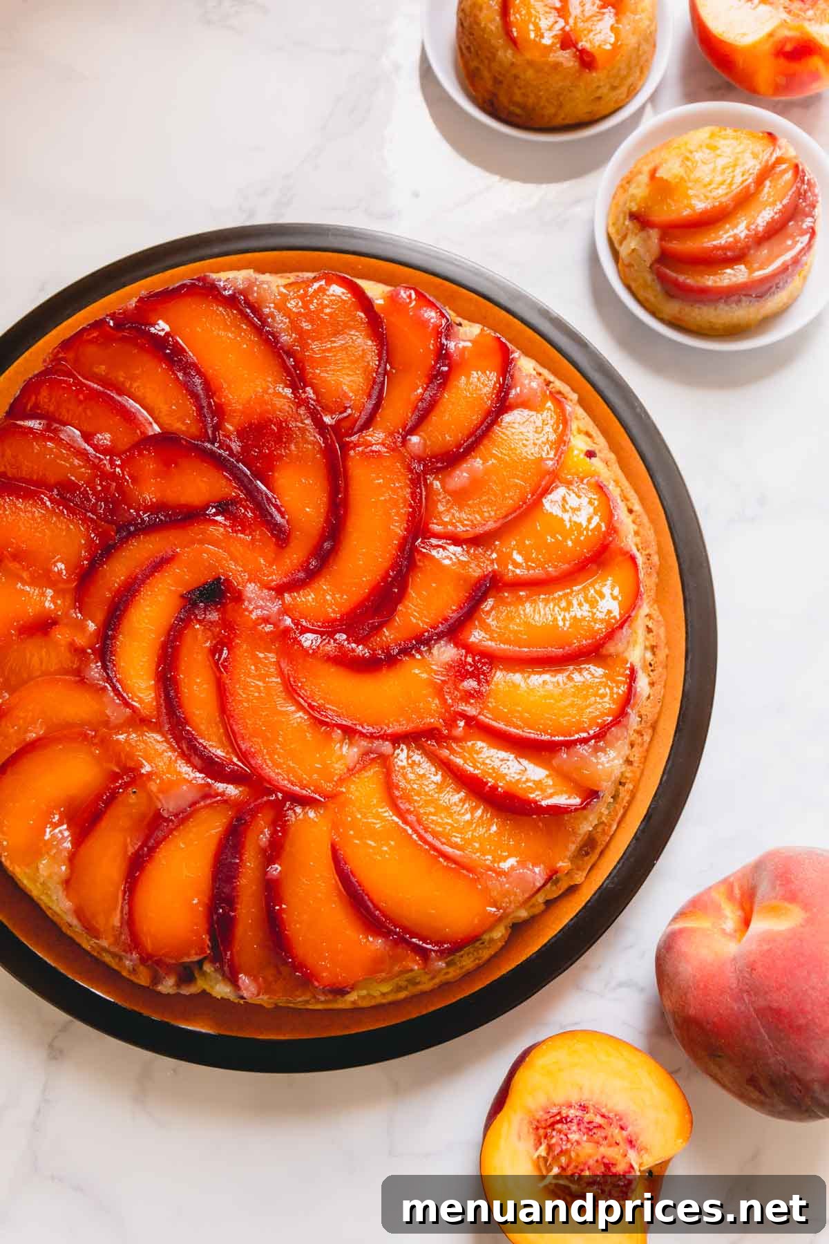 A round peach upside down cake on a larger serving plate.