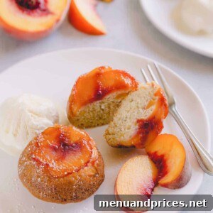 Peach upside down mini cakes on a white serving plate with vanilla ice cream and sliced peaches.