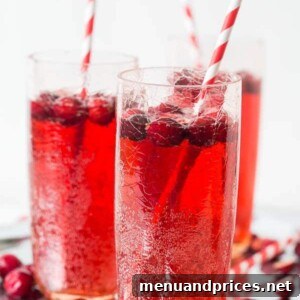 Cranberry Ginger Ale Punch garnished with fresh cranberries and lime.
