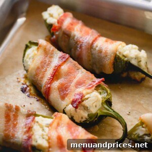 Cooked bacon jalapeno poppers on a baking sheet, showcasing their golden crispiness.