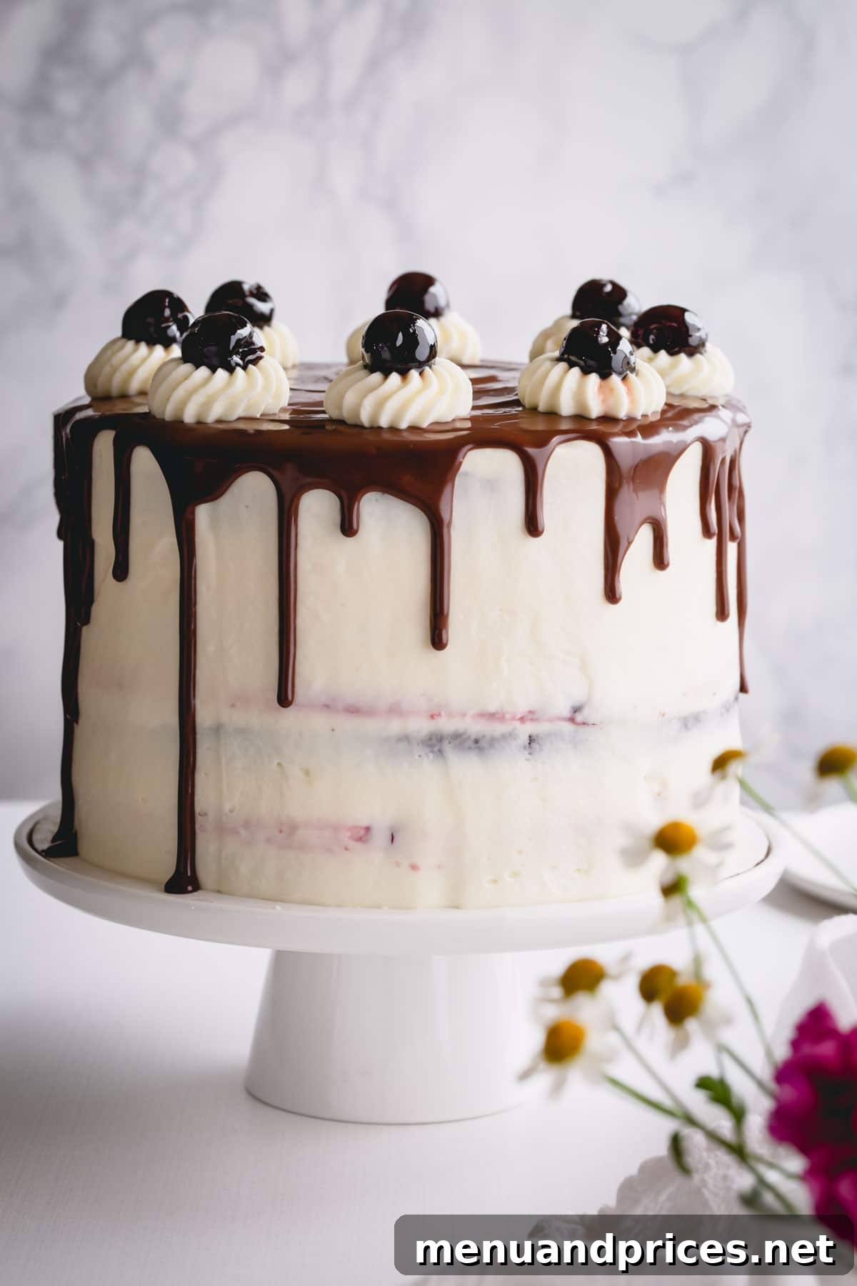 Decadent Black Forest Torte 2 Black Forest cake with chocolate drizzle on a white cake platter, ready to be served.