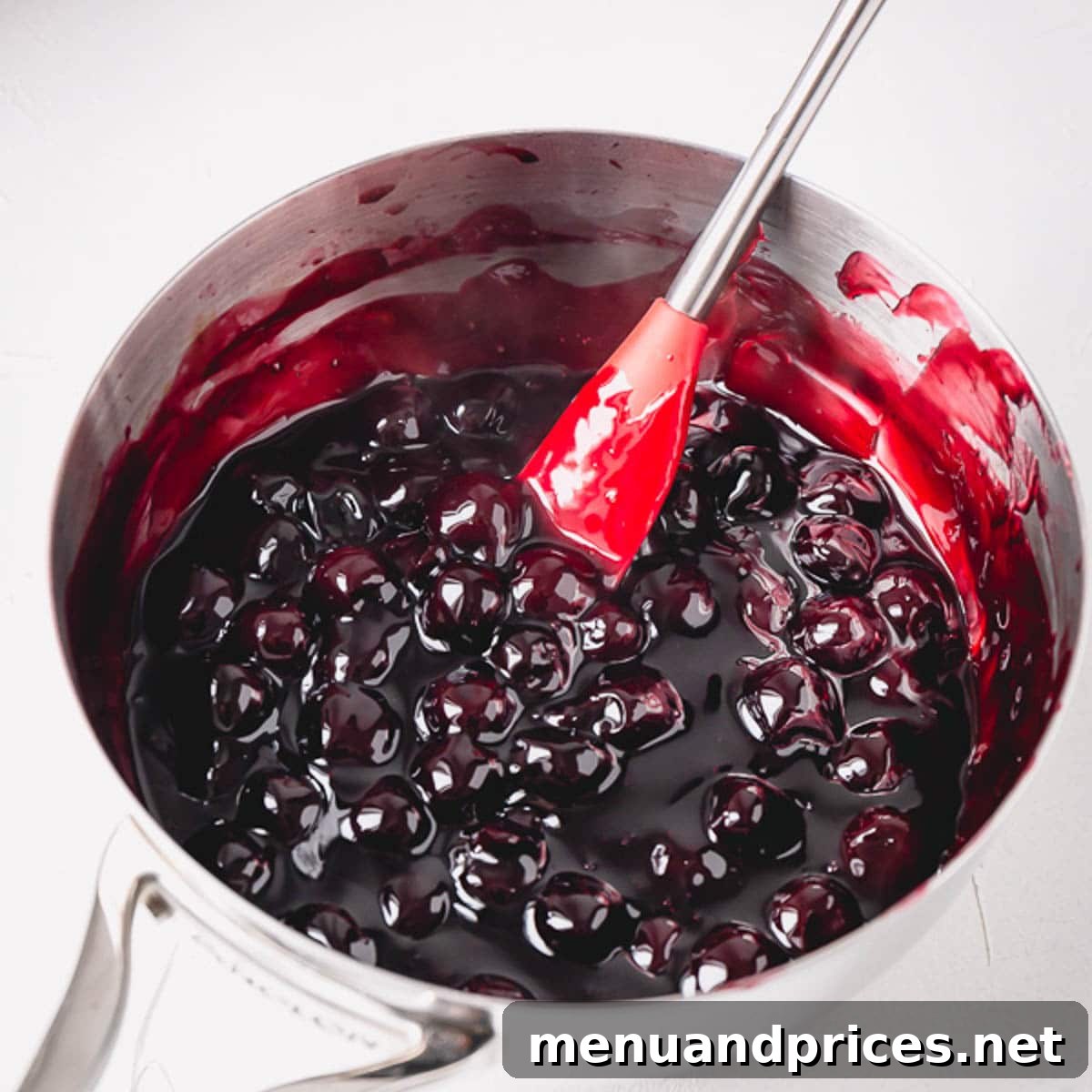 Decadent Black Forest Torte 4 Homemade cherry pie filling simmering in a stainless steel saucepan.