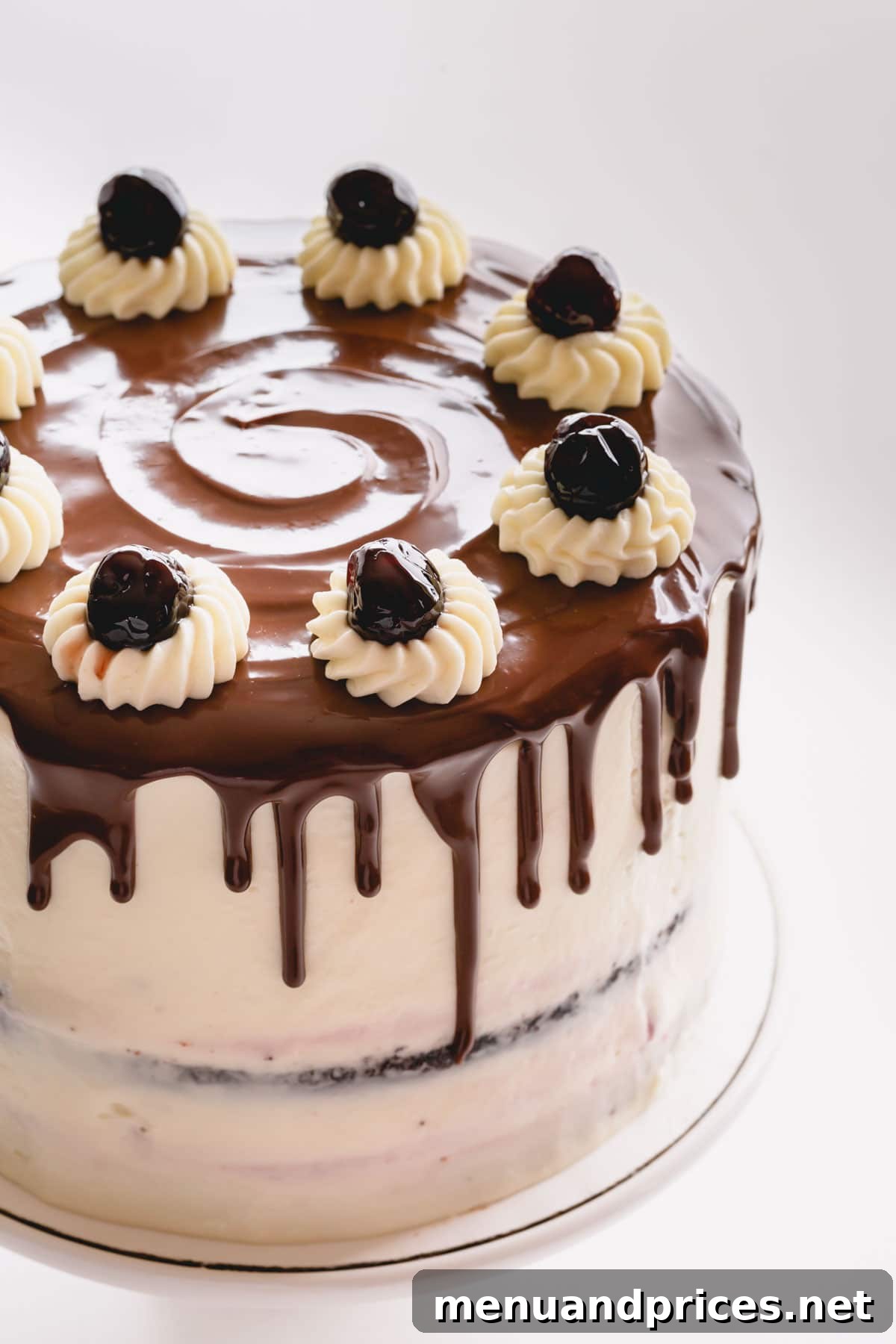 Decadent Black Forest Torte 7 Black Forest cake decorated with chocolate drizzle and canned cherries on top.