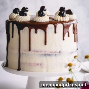 Black Forest cake with chocolate drizzle on a white cake platter.