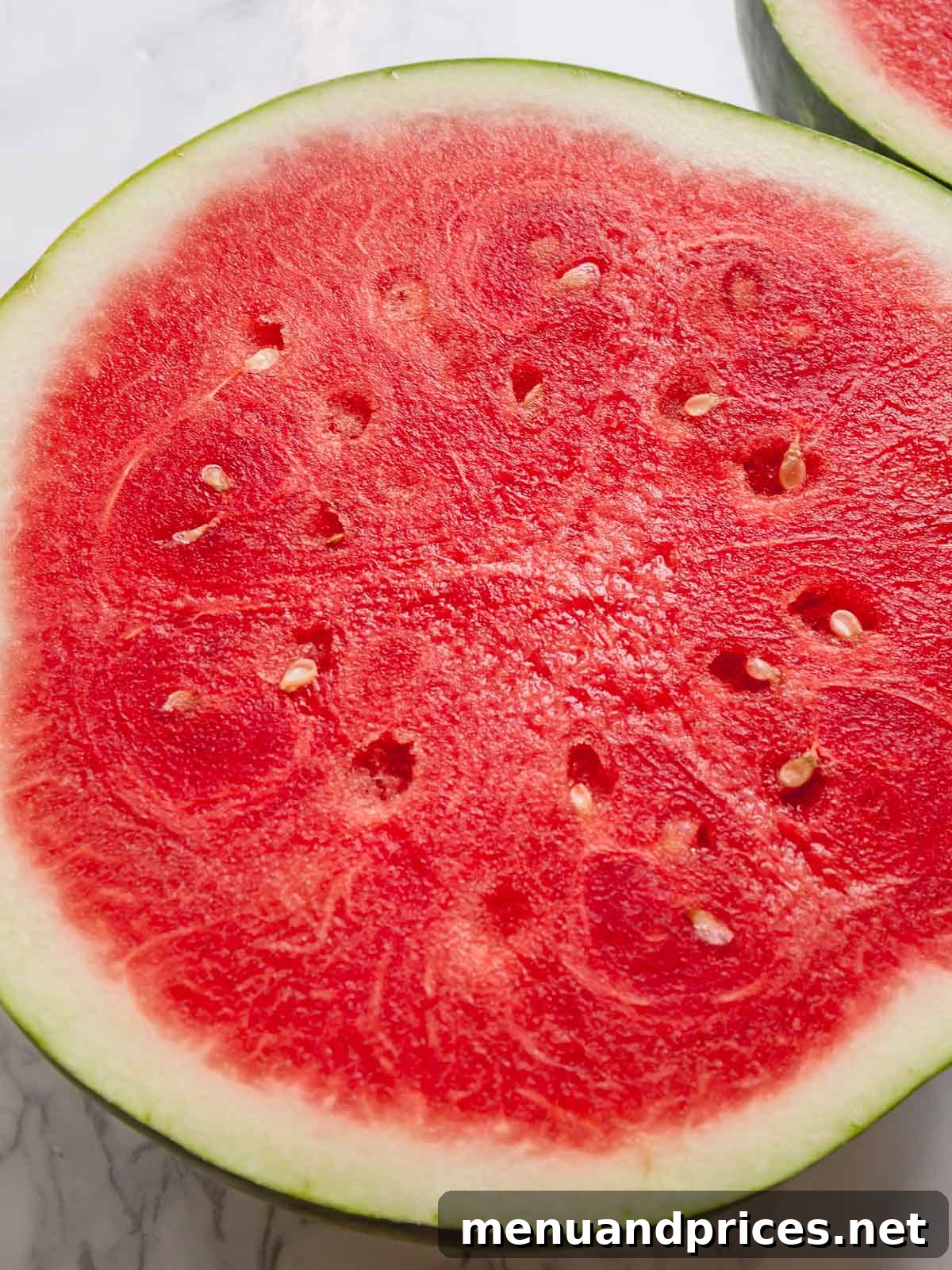 Sliced watermelon half featuring a bright red seedless flesh.