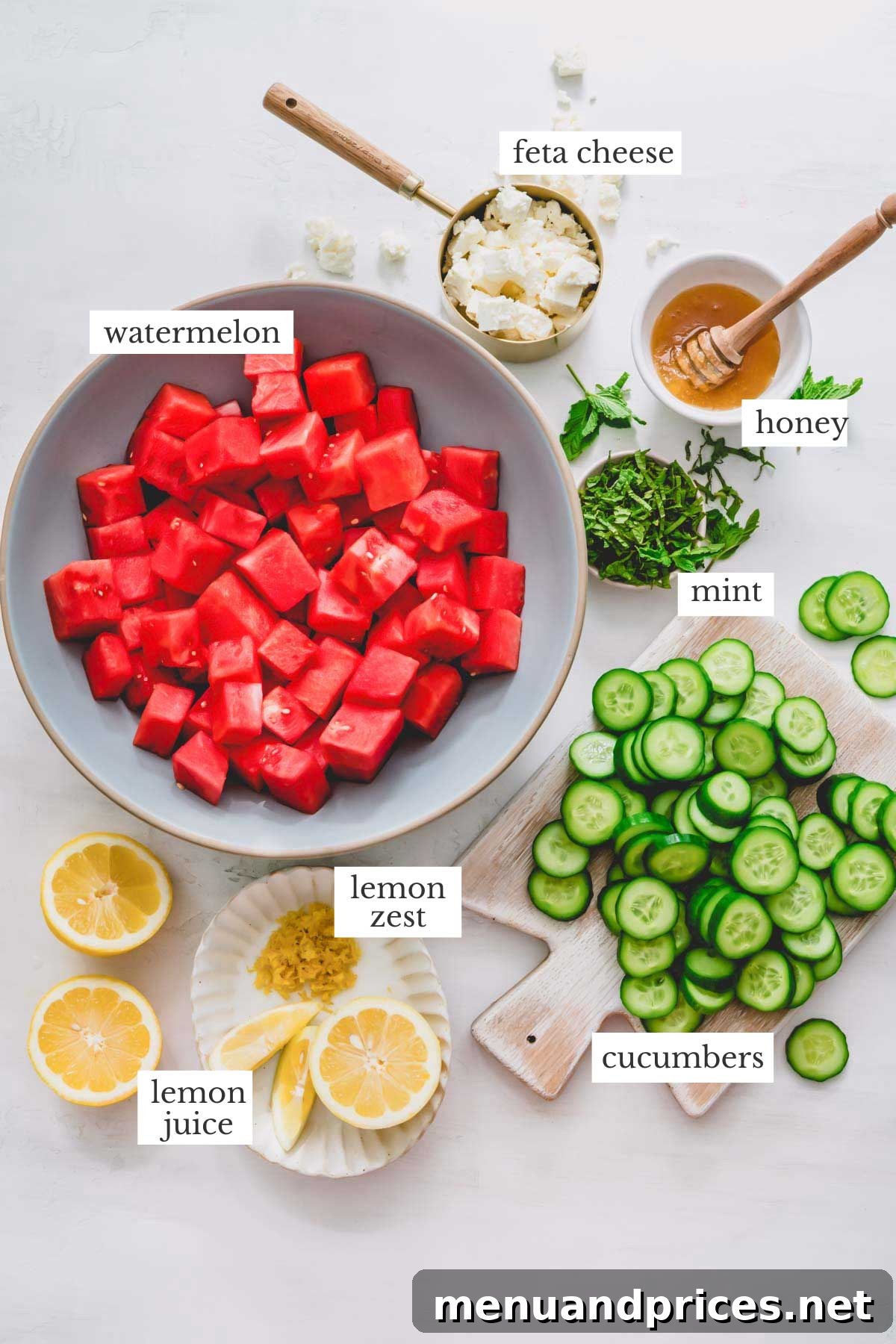 Summer Watermelon Feta Medley 3 A collection of fresh ingredients for watermelon feta salad, including watermelon cubes, cucumbers, feta cheese, and mint leaves.