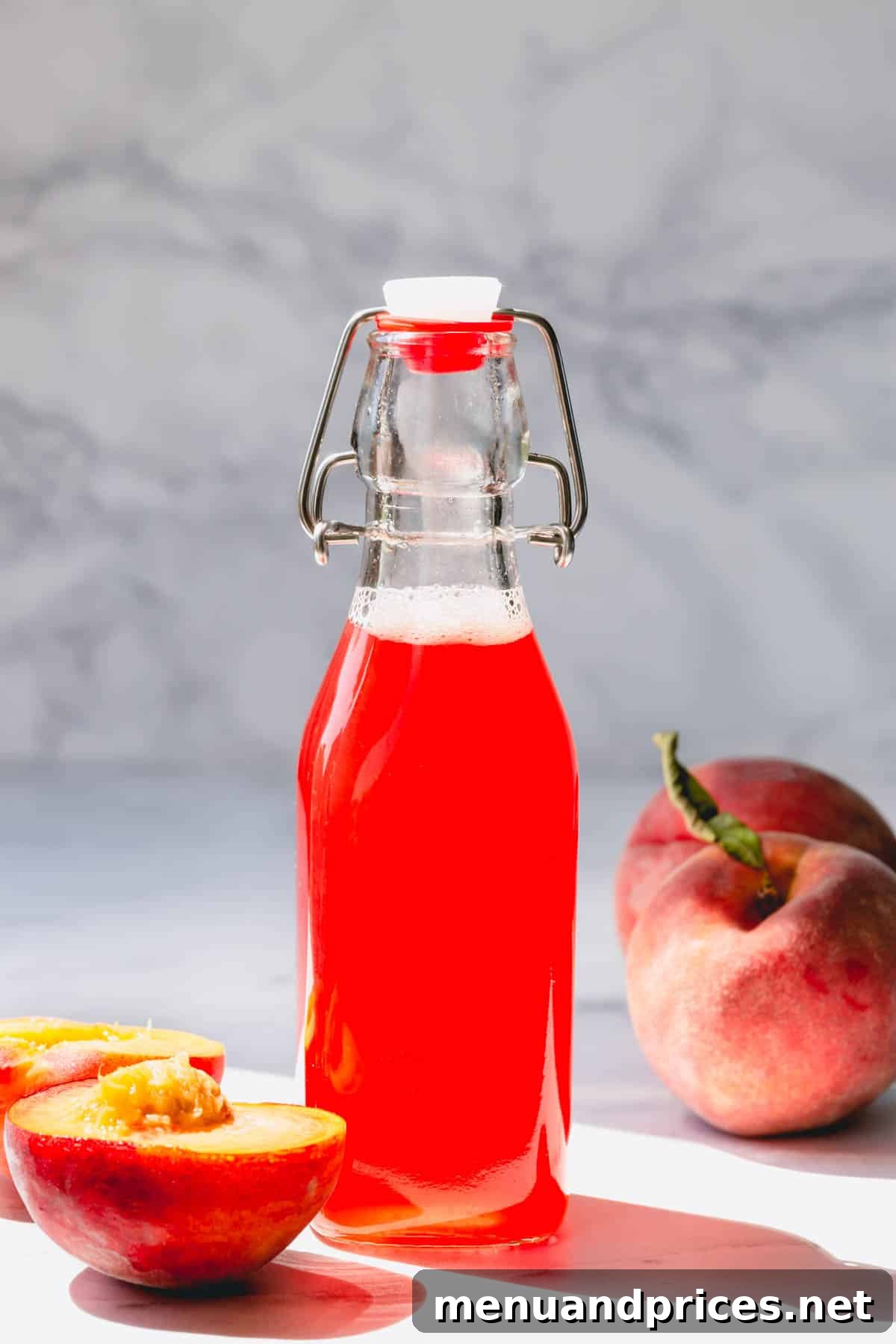 Homemade peach syrup in an elegant tall glass bottle, ready for use.